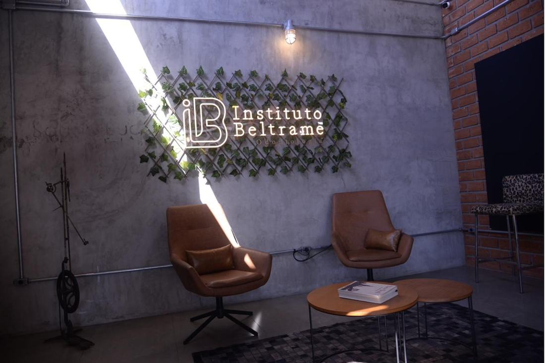 Recepção do Instituto Beltrame, com o letreiro da marca sobre a parede de folhagem